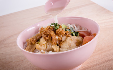 Fried fish served with rice noodles soup. Topped with chilli sauce. Taken in Singapore.