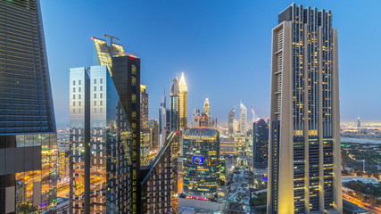 Obraz premium Skyline view of the buildings of Sheikh Zayed Road and DIFC day to night timelapse in Dubai, UAE.