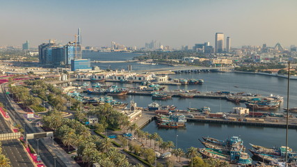 Fototapeta na wymiar Dubai creek landscape timelapse with boats and ship in port and modern buildings in the background during sunset