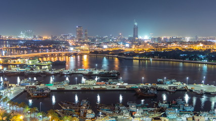 Dubai creek landscape night timelapse with boats and ship near waterfront