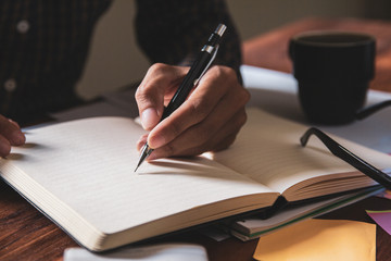 Asian young business man of student holding a pen writing letter on paper at home