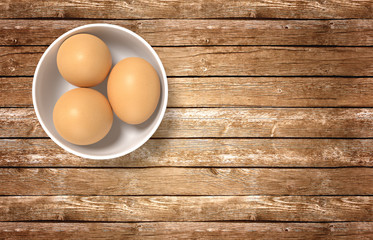Render of white ceramic bowl ful of eggs. Placed on wooden table.