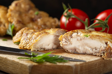 Schnitzel made from pork brain, flour and eggs on a wooden cutting board