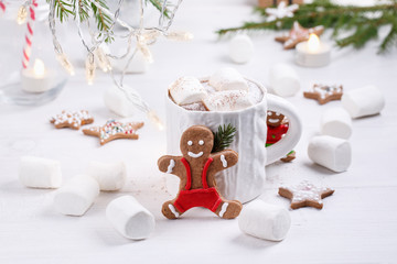 Cup of traditional hot chocolate with marshmallows and gingerbread on white table.  Christmas drink in New Year decorations.