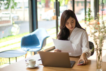 Fototapeta na wymiar Portrait of Asian pretty young business woman sitting on workplace