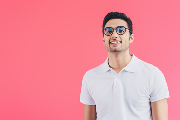 smiling handsome man looking at camera isolated on pink