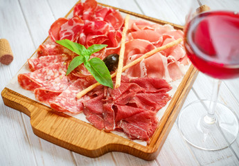 Italian meat antipasti set on wooden surfaces, jamon, prosciutto, salami, ham