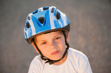 Fototapeta na wymiar portrait of little cute caucasian boy in sport blue helmet and white shirt