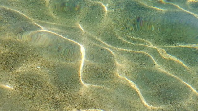 Sparkling sea water surface on sunny day at beach. Beautiful sun beams in ripple waves.