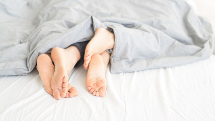 Affectionate of couple sleeping on the bedroom looks from their feet.