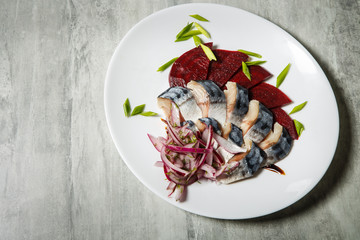 top view on mackerel and beet slices with chopped red and green onion