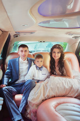 young beautiful caucasian couple bride and groom with son in the car