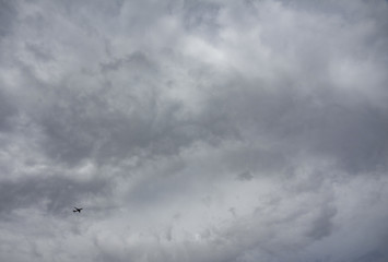 Small jet plane against huge cloudy sky