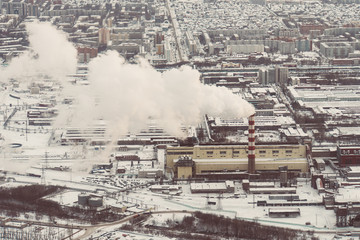 Air pollution by smoke coming out of two factory chimneys. Industrial zone in the city.