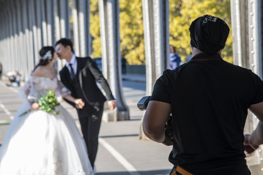 Japanese couple  having their wedding photo taken under Pont Bir Hakeim bridge, Paris, France