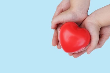 Adult and Child kid Hand holding Red Heart,Concept of Love and Health care,family insurance.World heart day, World health day.Valentine's day.isolated shape of heart on pastel blue background.