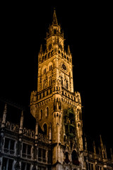 Fototapeta na wymiar Night view of the illuminated old town hall with a clock on the tower.