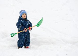 little boy in the snow with a shovel