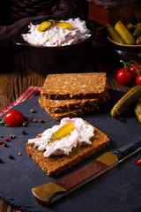 delicious spicy meat salad with cucumber on the black bread