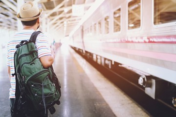 The passengers are stand waiting for the Station platform. Young man traveler with backpack looking waiting for train. the tourist travel Get ready for departure concept.