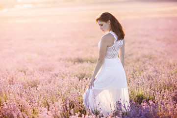 Fototapeta na wymiar Beautiful girl walk on the field of lavender