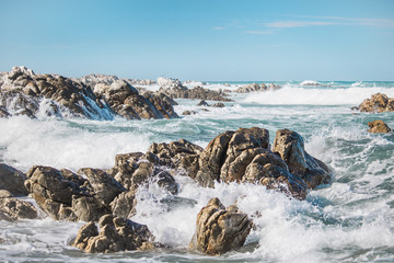 Dramatic crashing waves hitting rocks on the shore.
