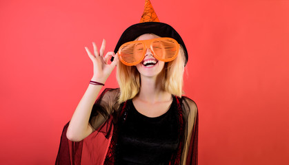 Halloween witch in hat show ok sign. Happy girl in halloween costume&big sunglasses. Witch magic....