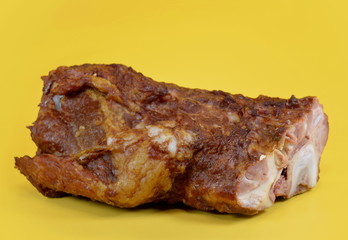 Smoked pork ribs close-up, isolated on yellow background