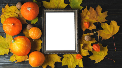 Naklejka na ściany i meble Empty thanksgiving greeting frame with pumpkins and autumn leaves on dark wooden background