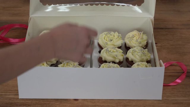 Girl child retrieves capcake from the box. Fragrant, vanilla capcake with berry filling and honey cream cheese, close up