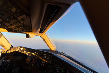Airplane flying at high altitude in the sky. Seen from inside cockpit in the morning sunrise....