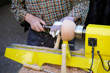 unrecognizable craftsman turning wood with lathe, woodworking craftsmanship