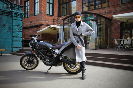 Woman and retro cafe racer motorcycle