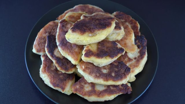 Potato cakes, ukrainian name potato zrazy, stuffed mushrooms or meat or cheese with herbs cream are fried in vegetable oil on black background, close up, rotates. Traditional Ukrainian cuisine