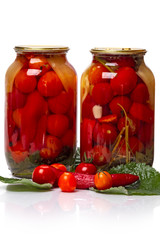 Two glass jars of canned tomatoes and fresh vegetable