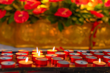 Burning candles in the Catholic Church. Selective focus. Bokeh. Red and gold colors.