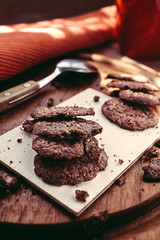 Chocolate thin cookies, American style. On a wooden board with daylight soft light