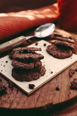 Chocolate thin cookies, American style. On a wooden board with daylight soft light