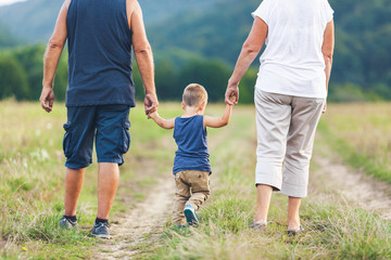 Happy grandparents on a walk with their grandchild