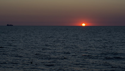sunset on a cloudless sky on the Baltic Sea shore in a calm