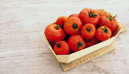 petit panier de tomates bio,sur fond bois