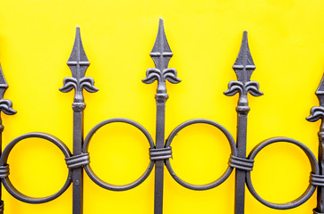 wrought iron fence on yellow background