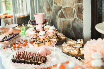 Delicious sweets on wedding candy buffet with desserts, cupcakes