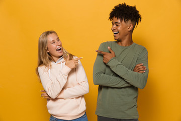 Photo of beautiful students man and woman 16-18 with dental braces laughing to each other, isolated...