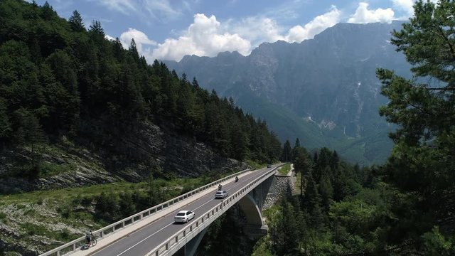 Aerial - Traffic and a mountain biker on a mountain viaduct in spring