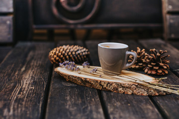 A cup of coffee on a wooden stand.