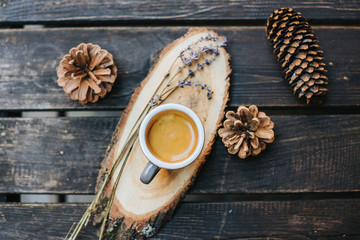 A cup of coffee on a wooden stand.