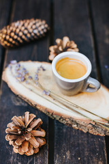 A cup of coffee on a wooden stand.