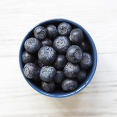Blueberries in a blue bowl, overhead view. Flat lay, overhead, from above. Close-up.