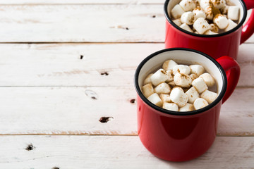 Christmas cocoa with marshmallow in mug on white  wooden table. Copyspace